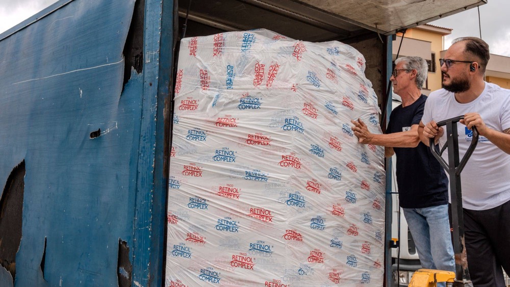 Due operatori guidano il carico sulla sponda idraulica del camion